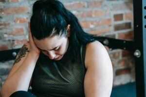 crying woman feeling tired during training in gym